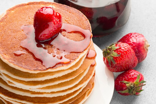 High angle pancakes with strawberry syrup
