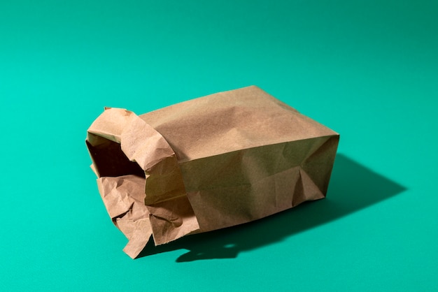 Бумажный пакет с высоким углом на зеленом фоне