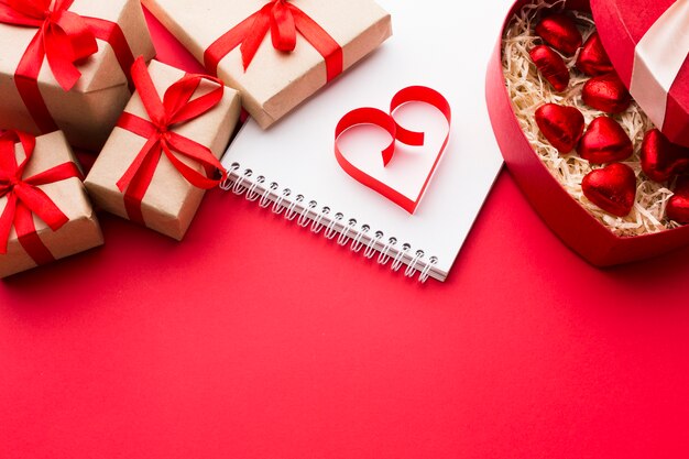 High angle of paper heart shape with presents and sweets