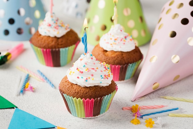 Free photo high angle party hats and glazed muffins