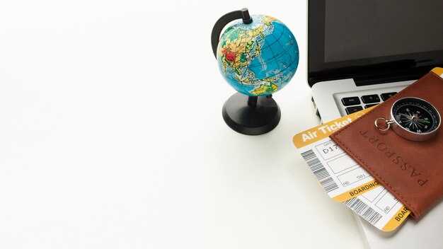 high angle passport, compass and laptop