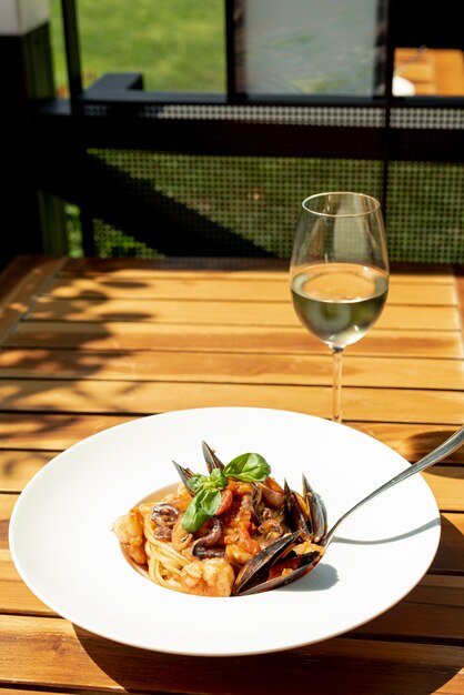 High angle of pasta and wine on wooden table