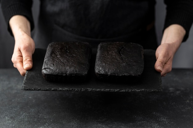 Free photo high angle of pastry chef holding pieces of cake