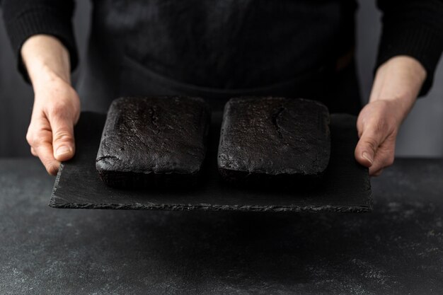 High angle of pastry chef holding pieces of cake