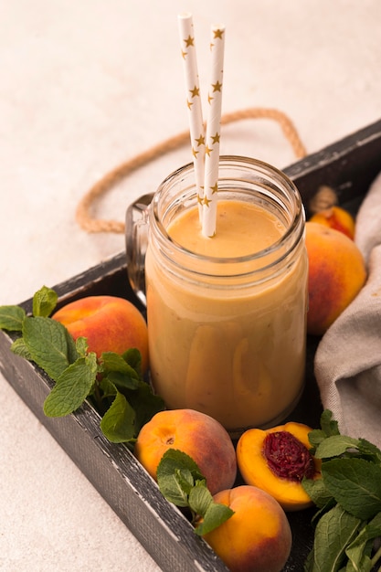 Free photo high angle of peach milkshake with straws