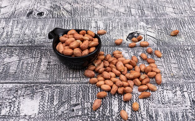 High angle peanuts in bowl on wooden gray horizontal