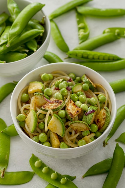 Free photo high angle peas with spaghetti and vegetables