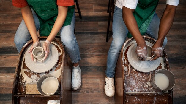 High angle people doing pottery