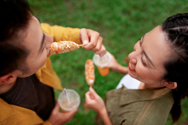 High angle people eating corn dog