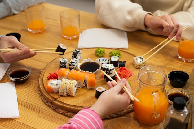 High angle people eating sushi at home