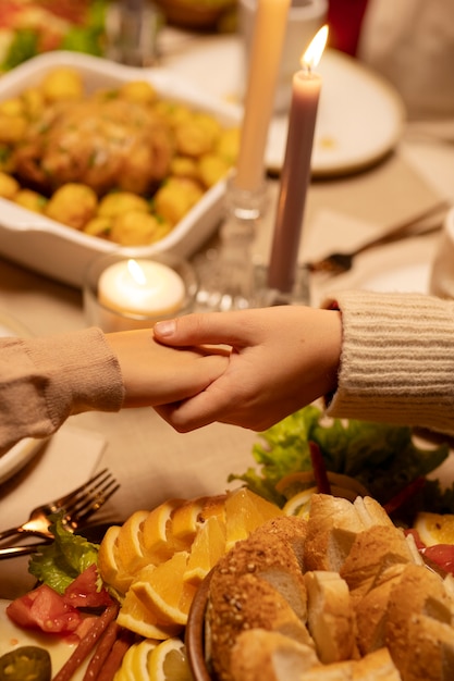 Foto gratuita persone ad alto angolo che si tengono per mano al tavolo