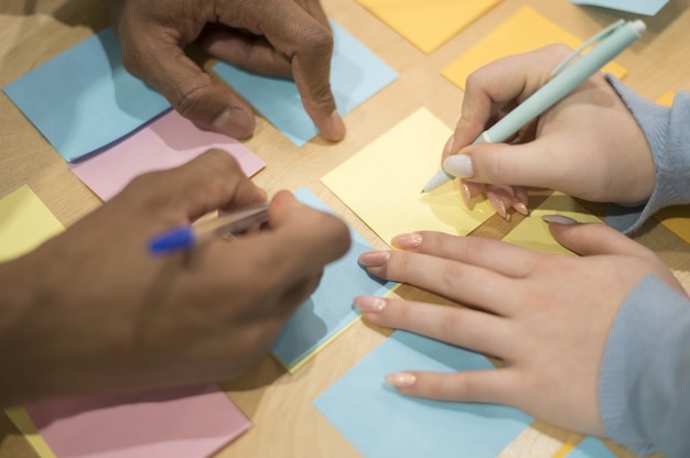 High angle of people at the office writing ideas on sticky notes