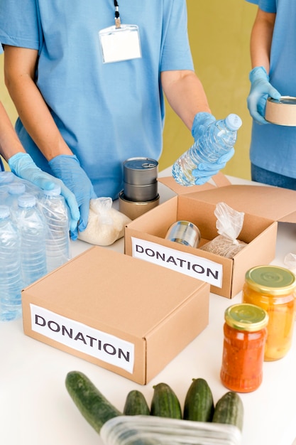 High angle of people preparing boxes with food donations