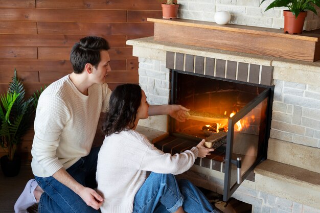 High angle people sitting by the fireplace