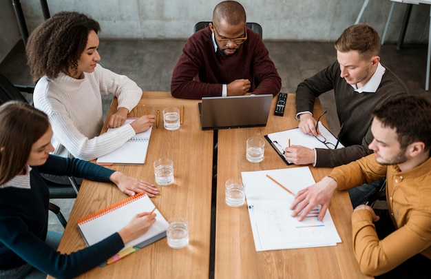 High angle of people at the table in the office during a meeting