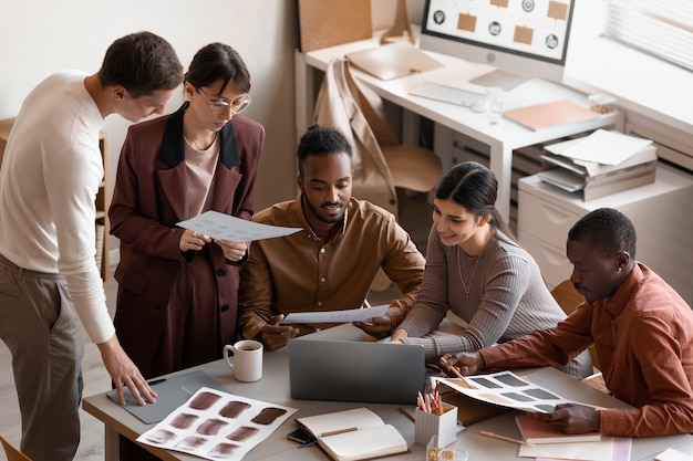 Foto gratuita persone ad alto angolo che lavorano alla scrivania