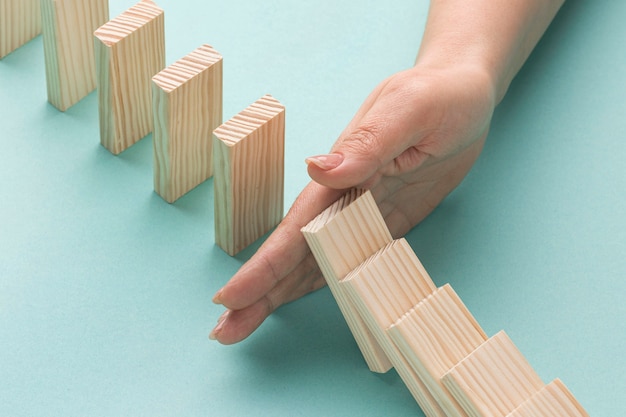 High angle person holding wooden pieces from falling