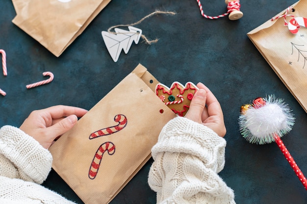 High angle of person putting treat inside christmas bag