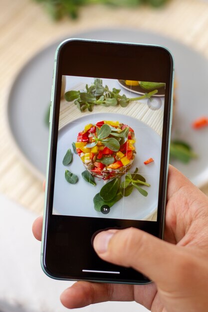 スマートフォンでプレート上の食べ物の写真を撮る人の高角度