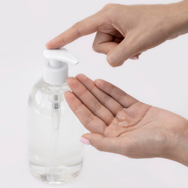 High angle person using liquid soap from a bottle