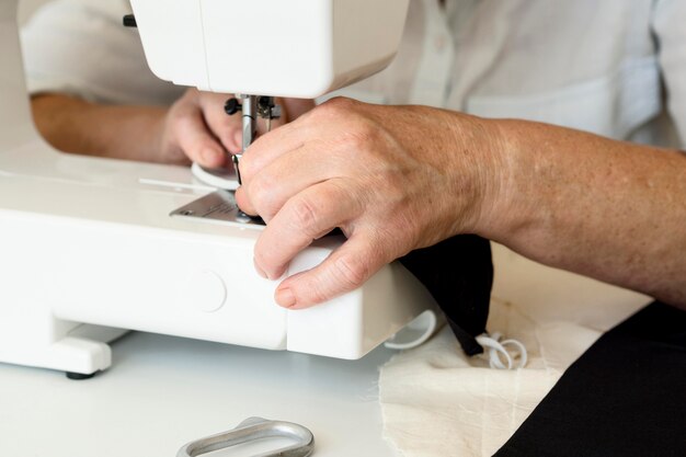 Free photo high angle of person using sewing machine for face mask