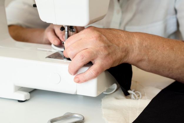 High angle of person using sewing machine for face mask