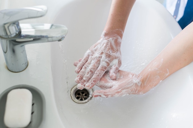 High angle of person washing hands in the bathroom