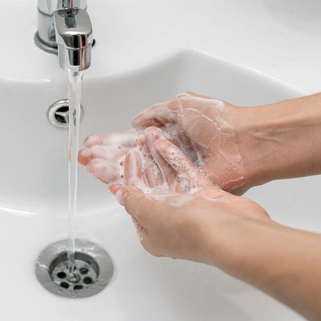 High angle person washing hands in a sink