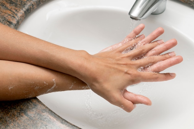 Человек под высоким углом моет руки