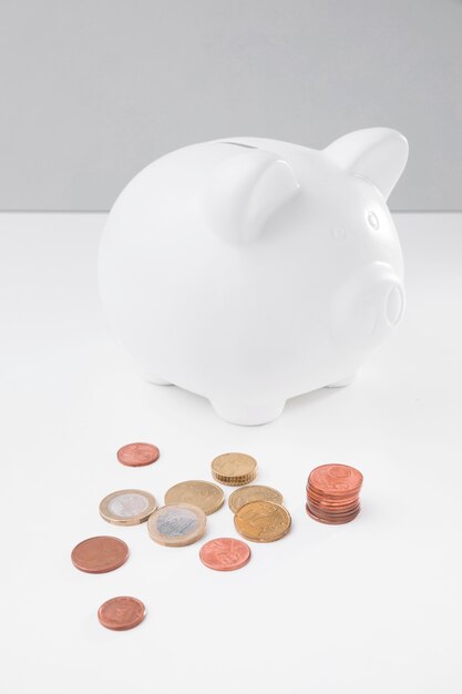 High angle piggy bank with coins beside