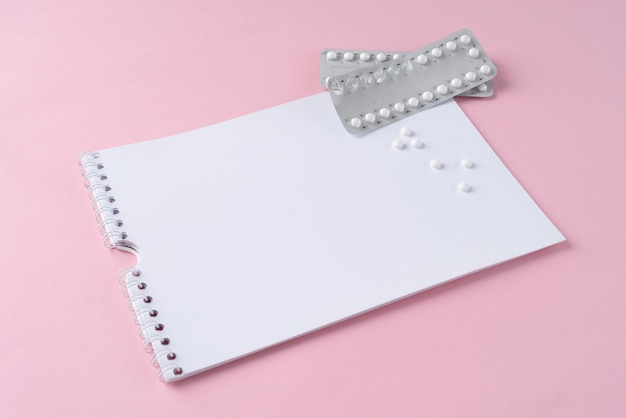 Free photo high angle pill foils and notebook