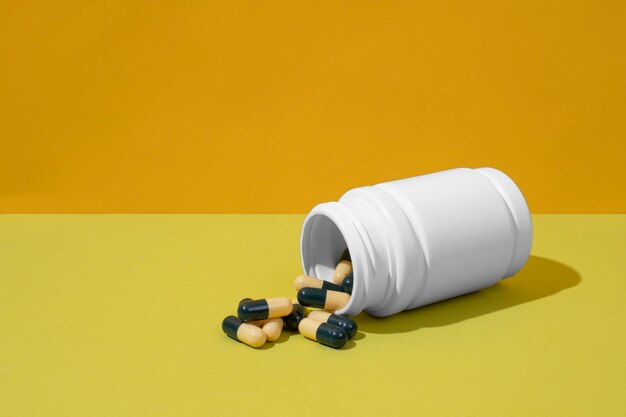 High angle pills container on yellow background