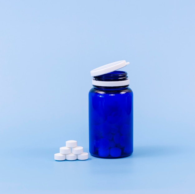 High angle of pills and plastic container with copy space