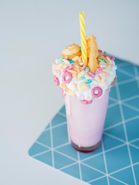 High angle pink milkshake with biscuit