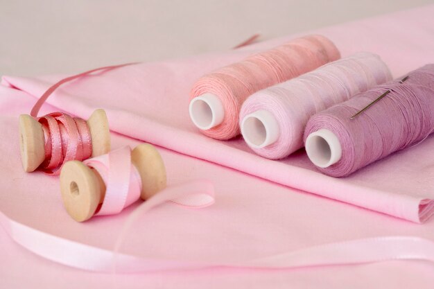 High angle of pink thread rolls with fabric