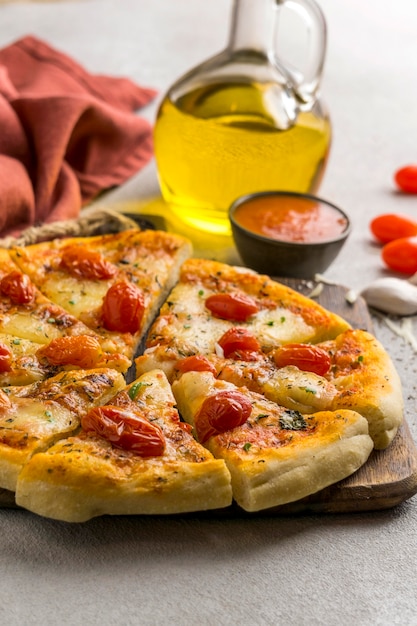 Alto angolo di pizza tagliata a fette con pomodori e olio