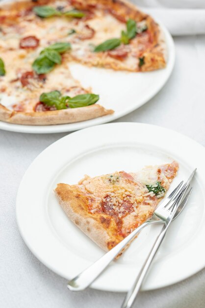 High angle of pizza slice on a plate on plain background