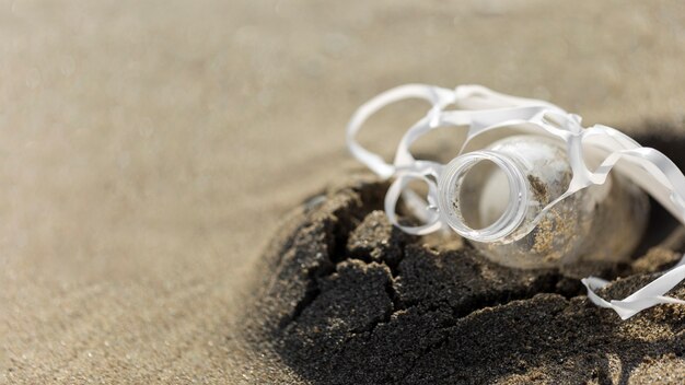 High angle plastic bottle in sand