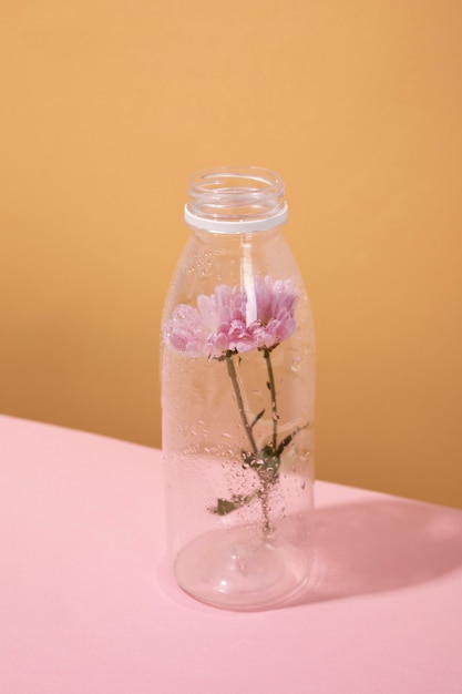 Free photo high angle plastic bottle with flower