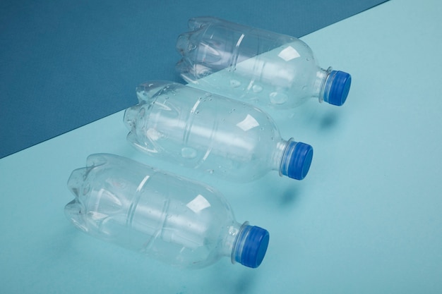 青い背景の上の高角度のプラスチックボトル