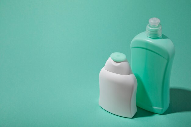 High angle plastic bottles on green background