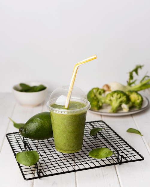 High angle plastic cup with green smoothie
