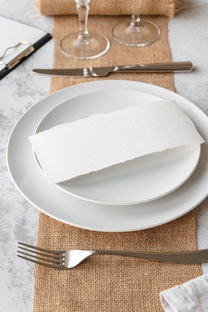 Free photo high angle of plate with empty paper and cutlery