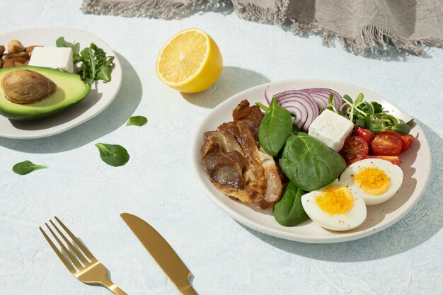 케토 다이어트 식품이 포함된 높은 각도의 접시와 아보카도와 견과류가 든 접시