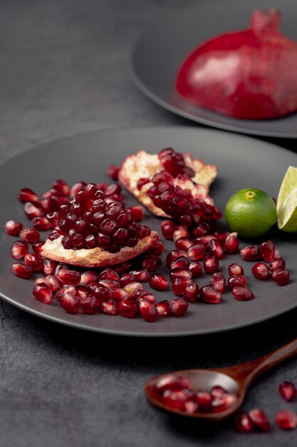 High angle of plate with pomegranate seeds and spoon