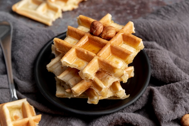 High angle of plate with waffles topped with honey and hazelnuts