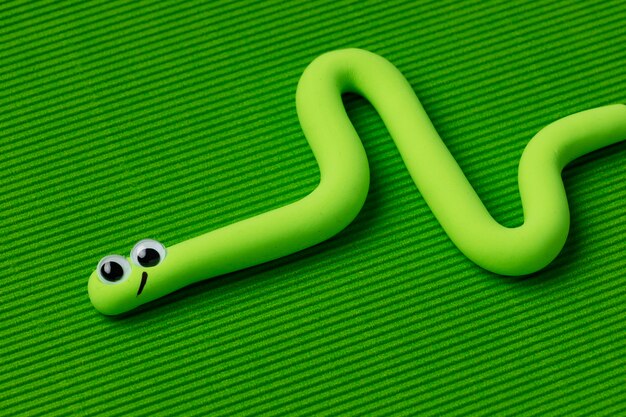 緑の背景を持つハイアングルプレイ生地ヘビ