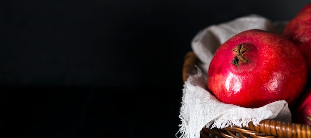 Free photo high angle of pomegranates in basket with copy space