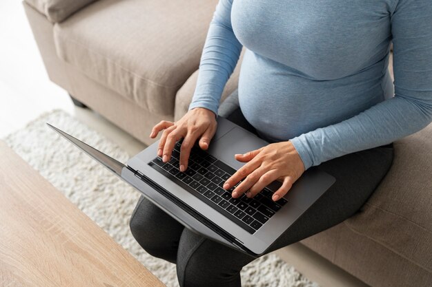 High angle pregnant woman working at home