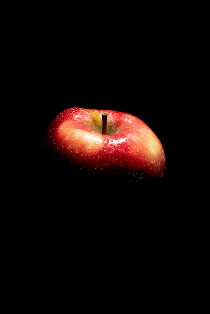 Красное яблоко под высоким углом на темном фоне